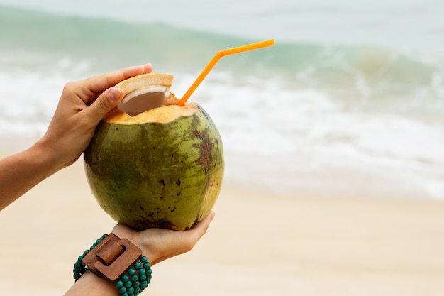 Photo female hands with a coconut