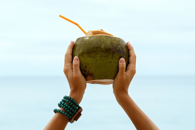Photo female hands with a coconut