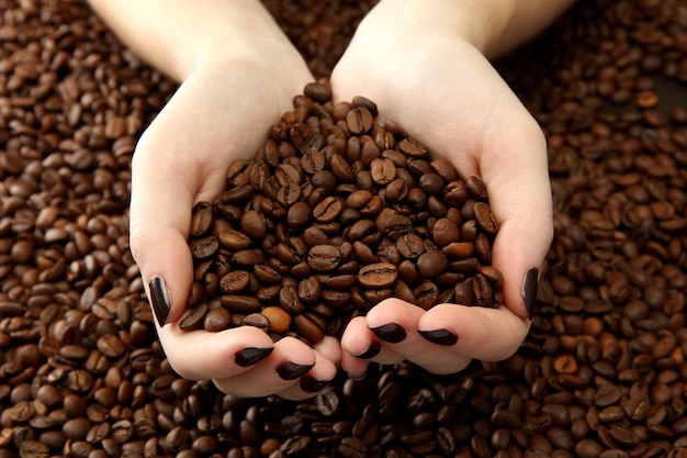 Female hands with coffee beans close up