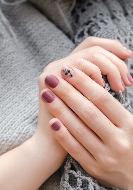 Female hands with dark pink nail design