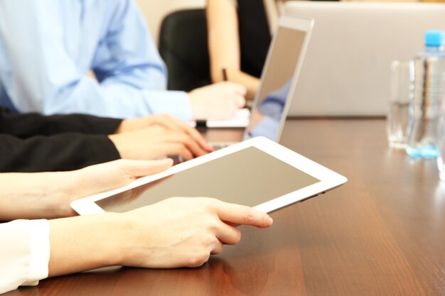 Female hands with digital tablet on office background