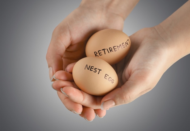 Female hands with   eggs  with retirement and nest egg