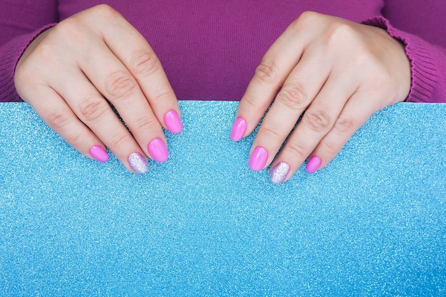 Female hands with lilac manicure holding paper