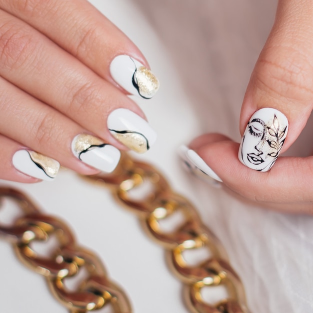 Женские руки с роскошным маникюром, ногтями, золотым гель-лаком