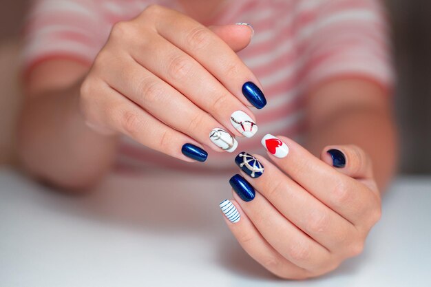 Female hands with manicure nails in marine style