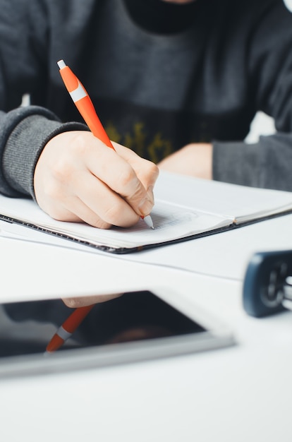 Female hands with pen writing on notebook