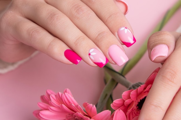 Женские руки с розовым маникюром, цветочный дизайн