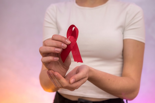 Female hands with red ribbon. Social advertising. Healthcare concept