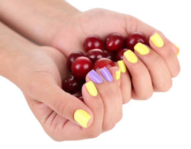 Photo female hands with stylish colorful nails holding ripe berries isolated on white