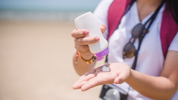 Female hands with sun protection cream at the beach Skin care concep