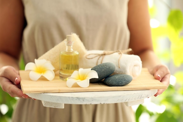 Female hands with tray of spa products at spa salon