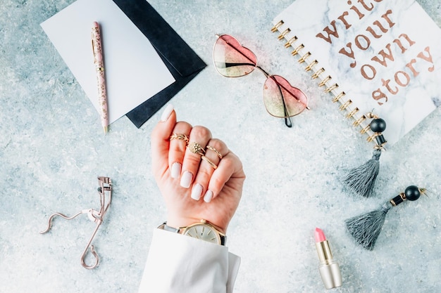 Female hands with a trendy glitter reverse french manicure over workplace background