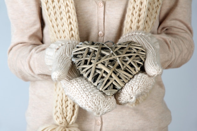 枝編み細工品の心を持つ女性の手、クローズアップ