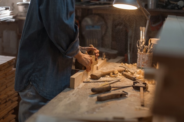 Le mani femminili lavorano con il legno. il concetto di lavoro manuale. stile di vita degli artigiani. laboratorio del legno