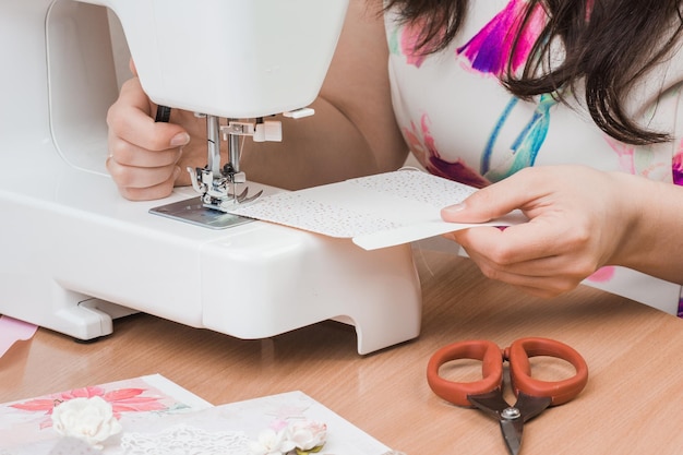 Female hands working for the white sewing machine Scrapbooking for wedding or other festive