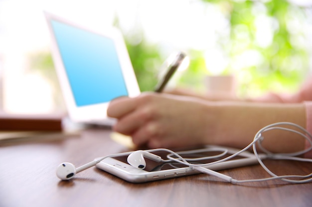 Female hands working with a laptop outdoor on blurred green plant background