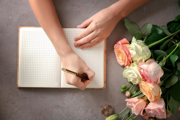 Photo female hands writing wedding to do list on table