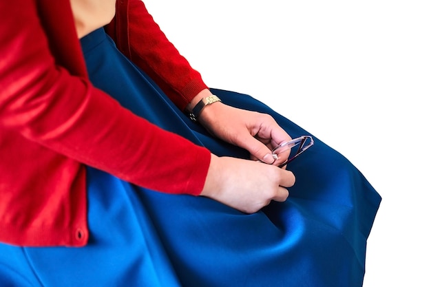Female hands Young woman in blue skirt and red blouse holding glasses Lecturer