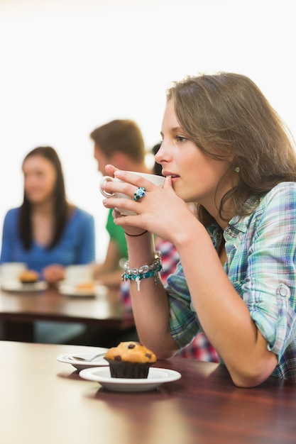 Female having coffee and muffin at  coffee shop