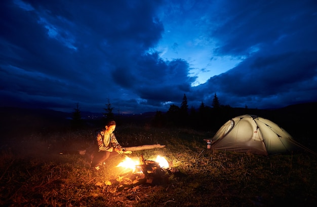 Female hiker resting at night camping