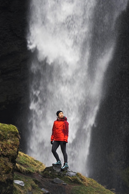 Female hiker with a view of Kvernufoss waterfall in South Iceland