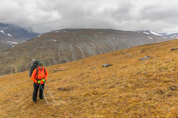 Female hiker witt backpack at Kungsleden trail admiring nature of Sarek