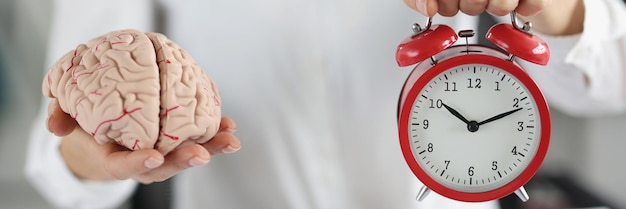 Orologio femminile della tenuta e lavoro in miniatura del cervello in corso per pensare