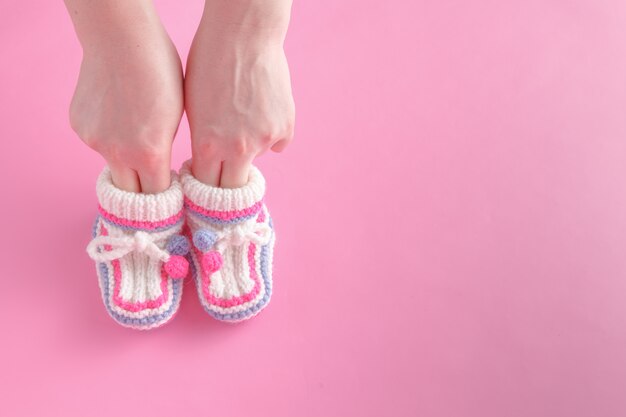 Female hold tiny newborn booties