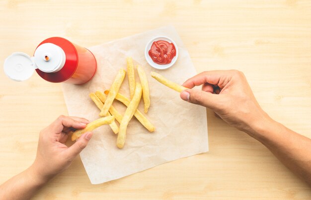 Female holding bottle sauce and fresh french fries