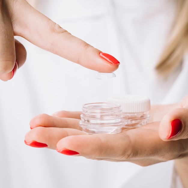 Female holding contact lenses closeup view