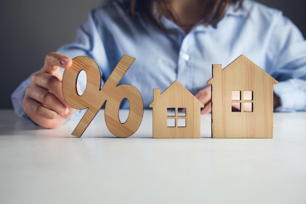 Female holding home model and sale percentage sign