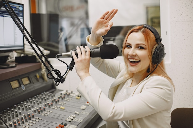 Photo female host communicating on microphone. woman in radio studio.