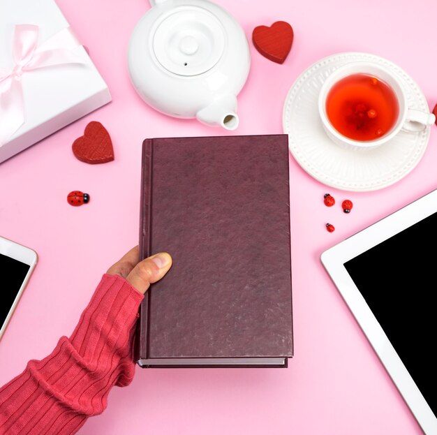  female human hand holds a book in a brown cover 