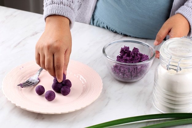 Female Indonesian Put Biji Salak Purple Sweet Potato Rice Cake (Candil Ubi Ungu), Cooking Process in te Kitchen Making Takjil for Buka Puasa Ramadan Breakfasting