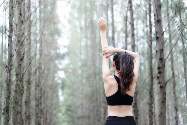 Female is stretching before exercise in the park on the morning