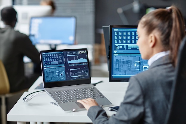 Female it security specialist using multiple computers