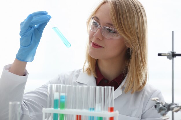 Female laboratory worker holding test tube with poison fluid