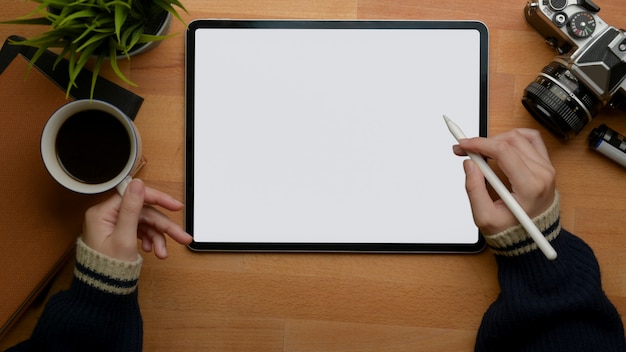 Женская левая рука держит чашку кофе и правый рисунок на планшете