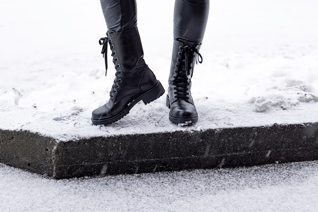 Female legs in black winter shoes