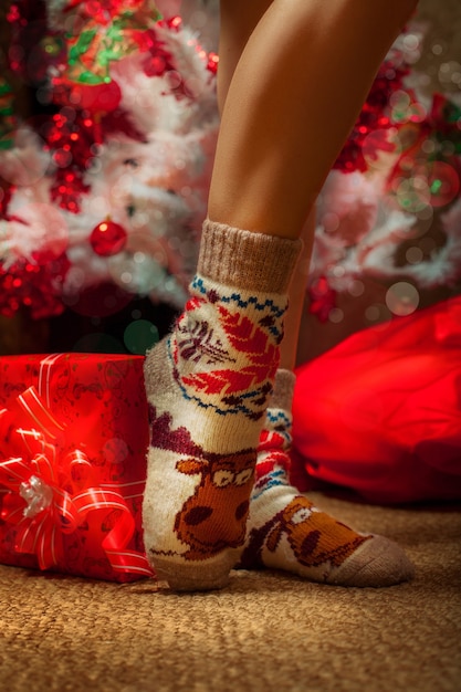 Female legs in funny socks with a lot of christmas gifts. Christmas mood. new year.