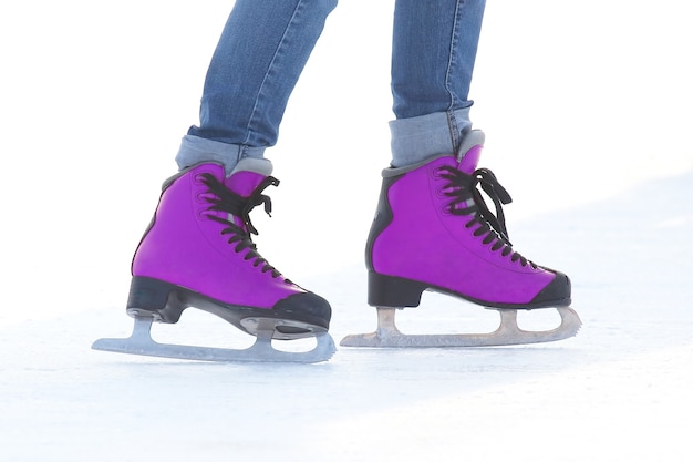 Фото Женские ножки в коньках на катке. спорт, хобби и отдых активных людей