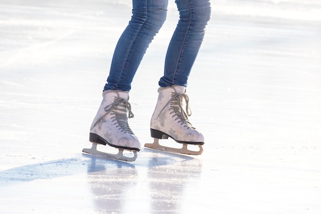 Female legs in skates on an ice rink