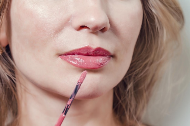 Female lips are painted with red lipstick closeup