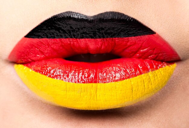 Female lips close up with a picture of the flag of Germany black red yellow