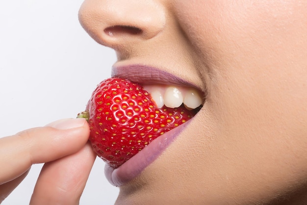 빨간 딸기를 먹는 여성 입술