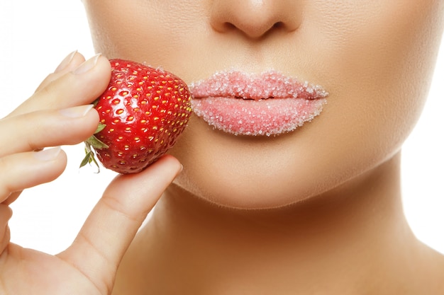 Female lips in sugar and strawberry