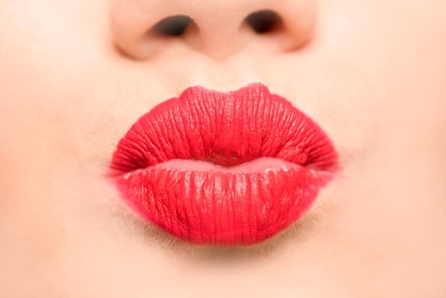 Female lips with red lipstick and a kiss gesture