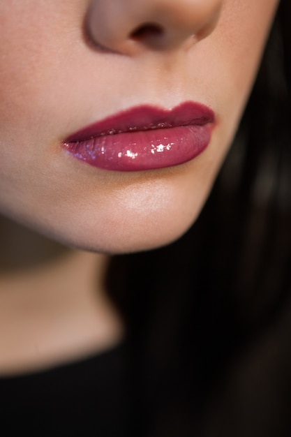 Photo female lips with shiny mauve lipstick close up