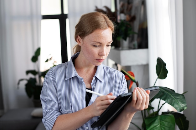 写真 グラフィックタブレットに取り組んでいる女性のロゴデザイナー