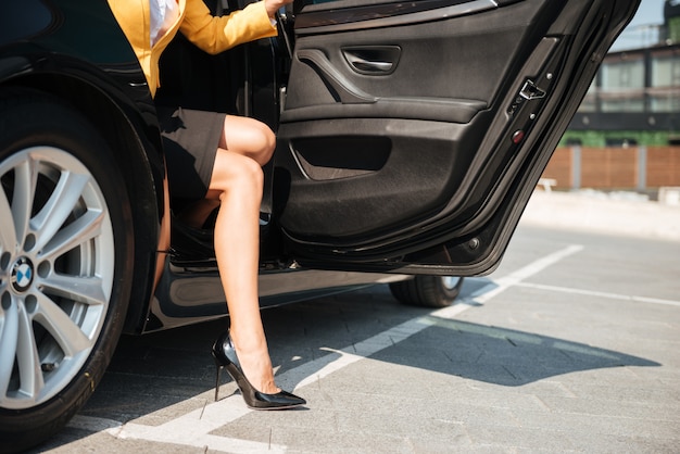 Female long legs getting out of her car